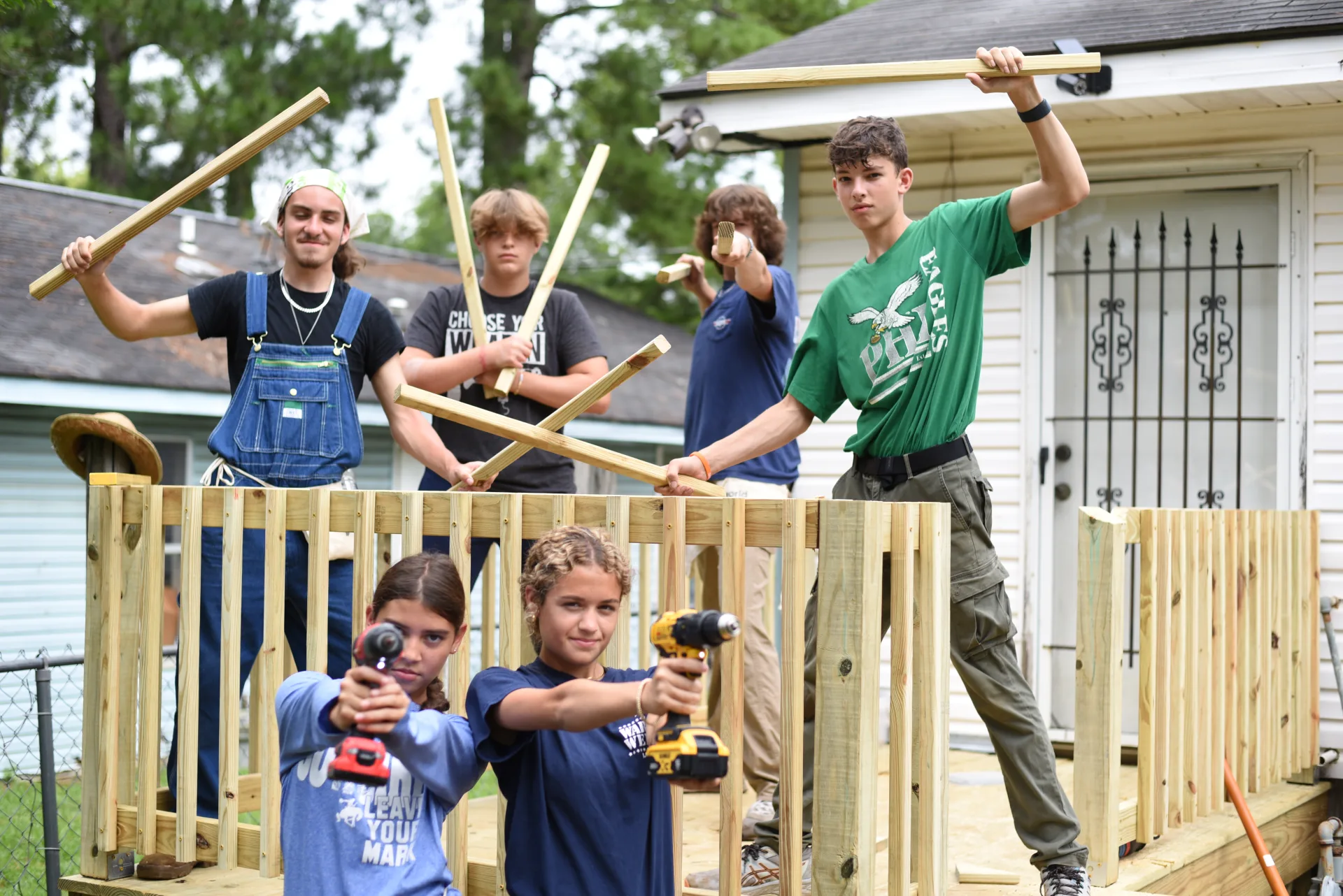 Students posing with tools on completed porch